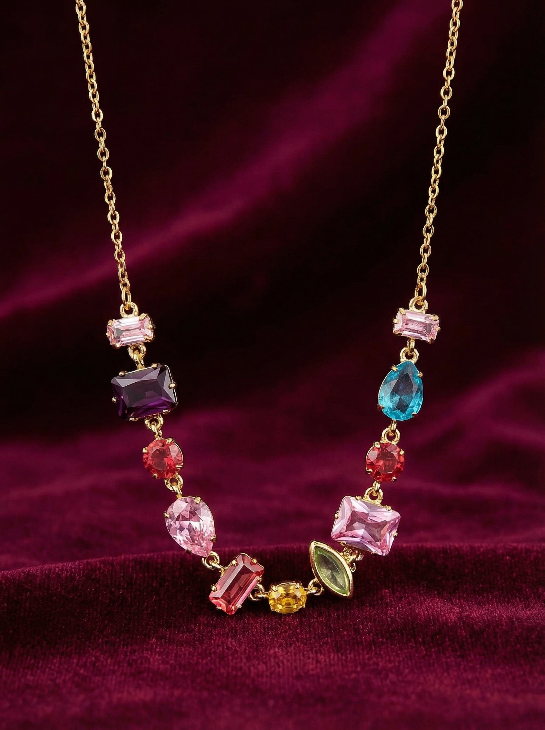 Necklace with multicolored gemstones on a purple fabric background