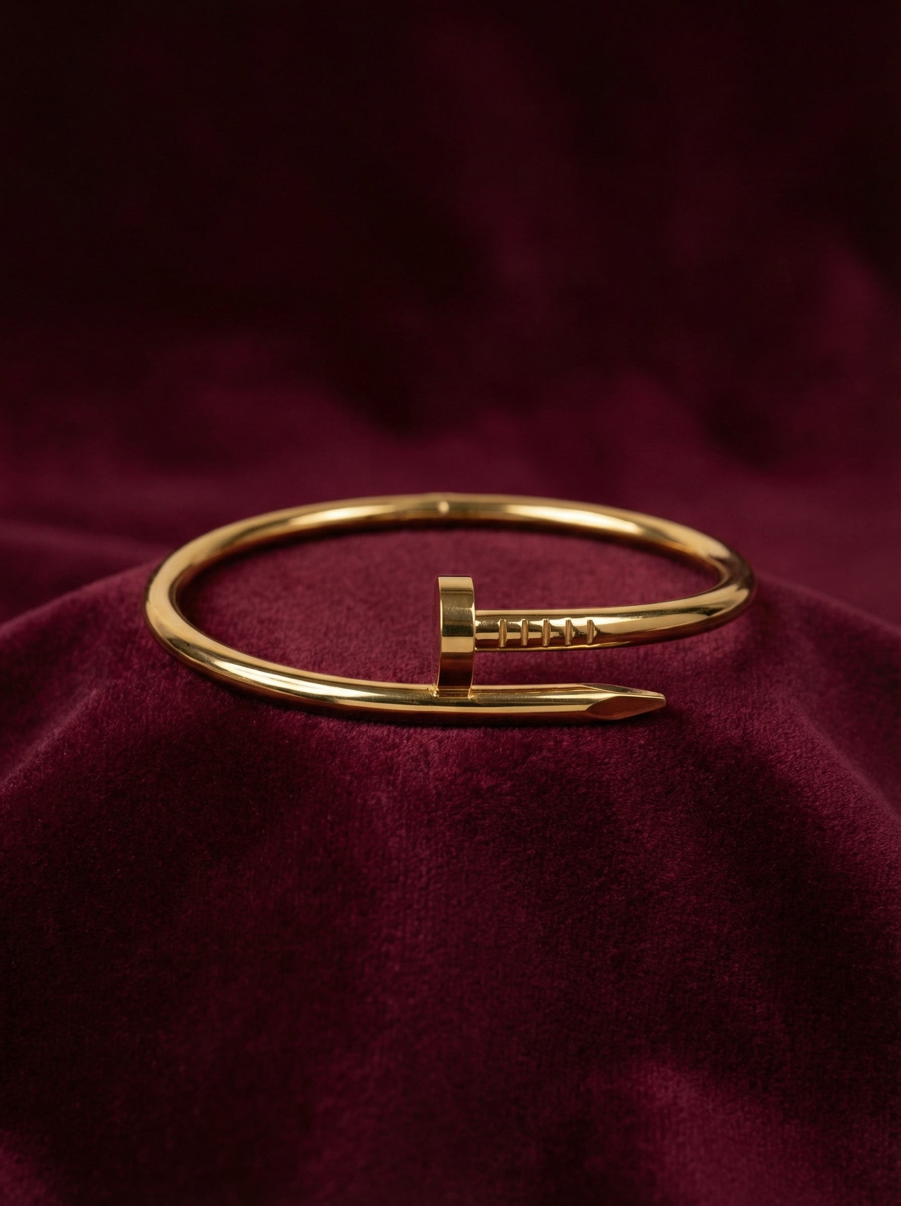 Gold bracelet on a burgundy fabric background