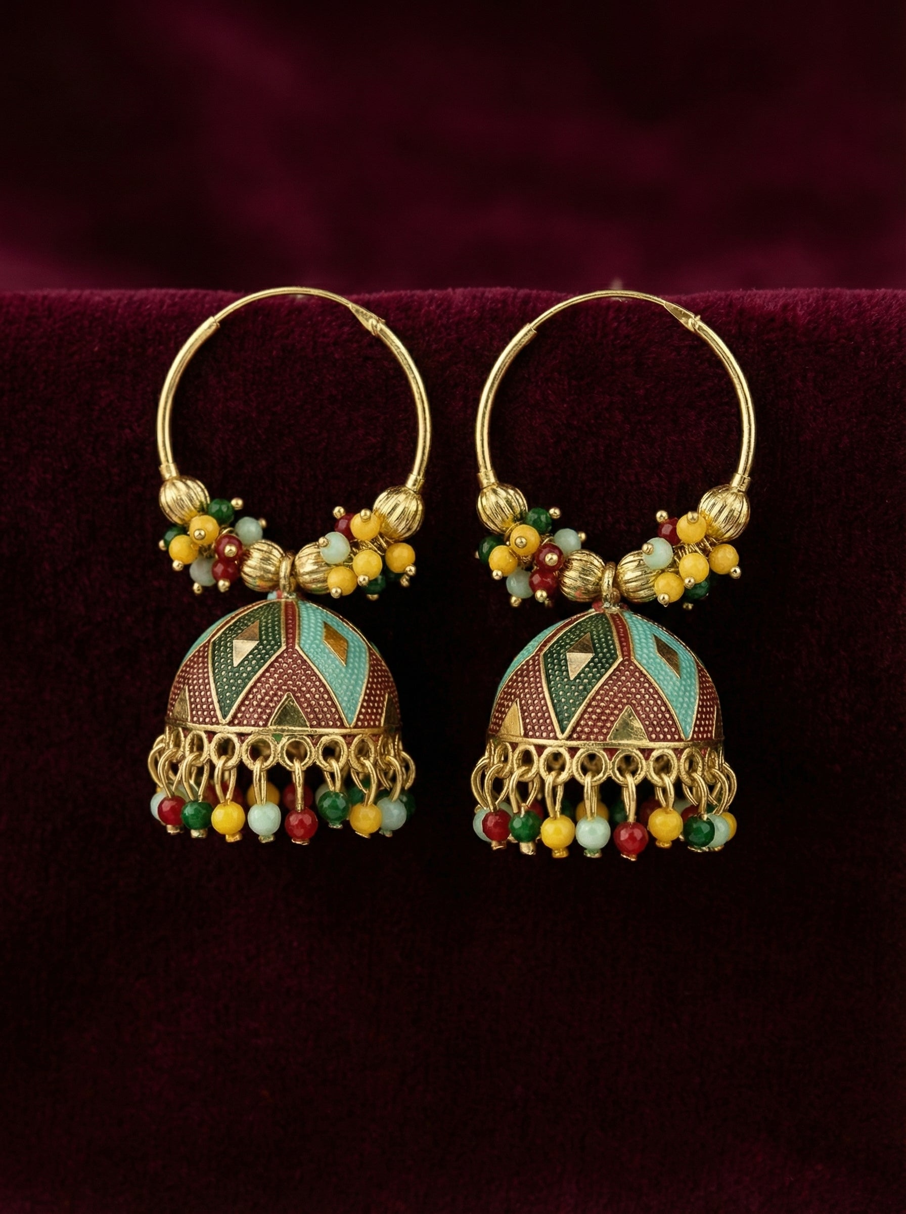 Ornate gold earrings with colorful beads on a dark background