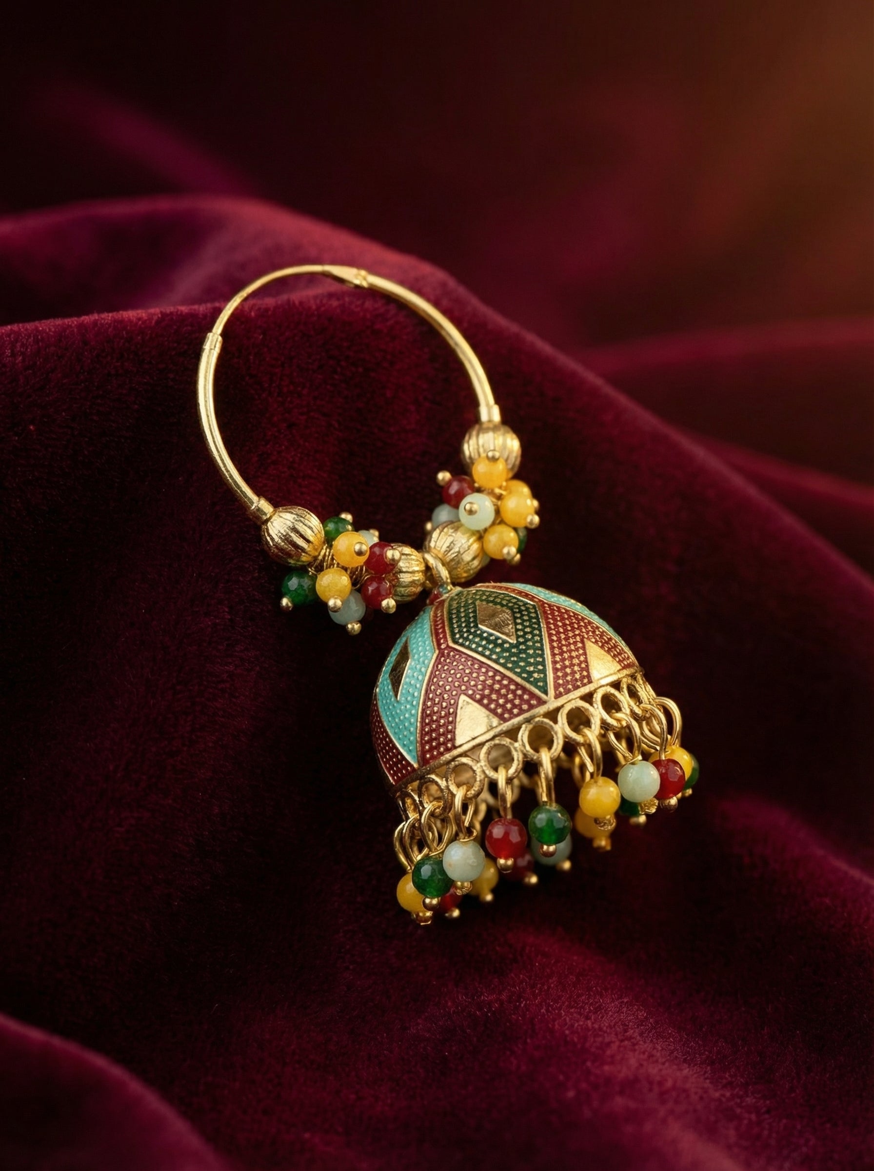 Decorative earring with colorful beads on a red fabric background